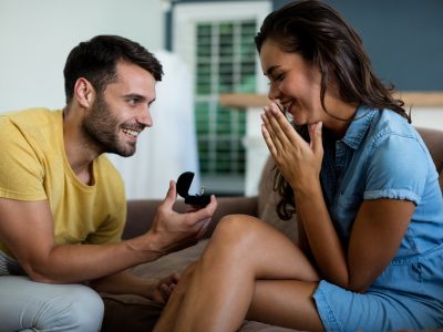 Man offering a engagement ring to woman in the living room