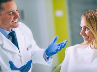 Young Dentist Talking to Satisfied Patient