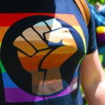 Black Power fist on gay pride t-shirt.