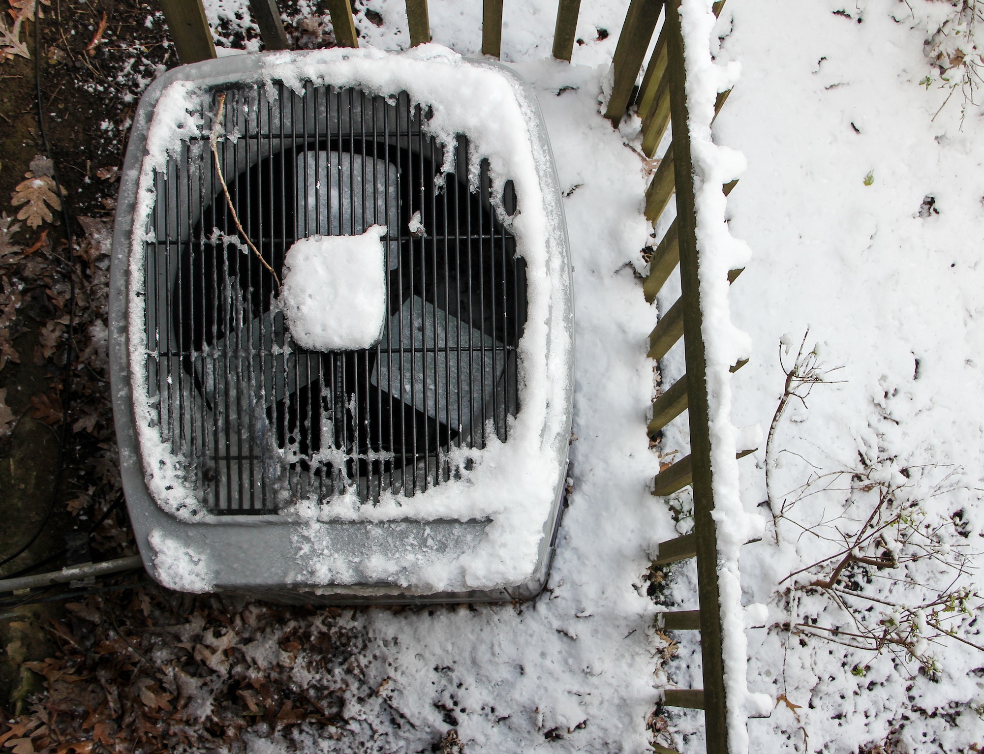 Overhead view of Central Air Conditioner HVAC unit covered with snow after snowstorm