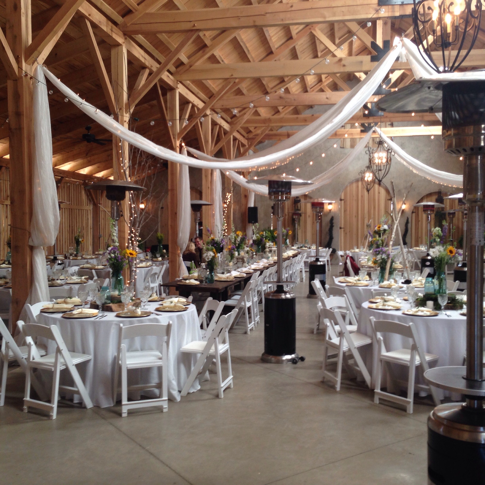 Wedding reception venue inside a timber frame barn here set up